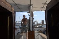 sailing cruises in sardinia : the skipper on rudder...